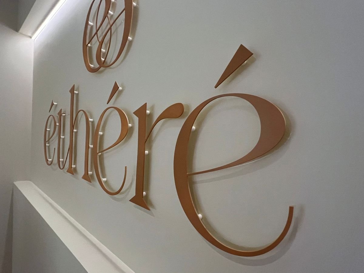 Enseigne en lettres découpées couleur cuivre « éthéré » fixée au mur sur entretoises, fabriquée et posée par L'Arène de la Com