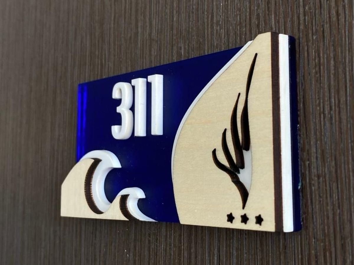 Signalétique hôtelière : plaque de numéro de chambre 311 en bois et plexiglas bleu, découpée et gravée à l'atelier